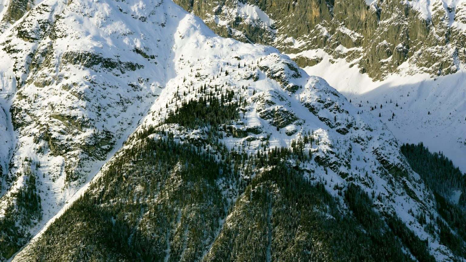 Photo by boris misevic An aerial view of a mountain range covered in snow